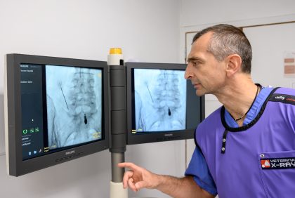 A radiologist looks at X-Rays on a monitor