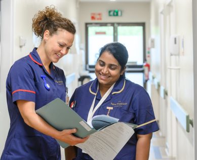 Nurses discuss a patient's notes