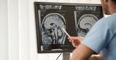 Technician studying head scans on screen